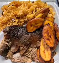 Plate photographed at the 2026 festival with roasted pork, rice, and plantains