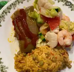 Festival plate with seasoned rice, shrimp, chicken, lettuce, tomato, cucumber, and a savory side.